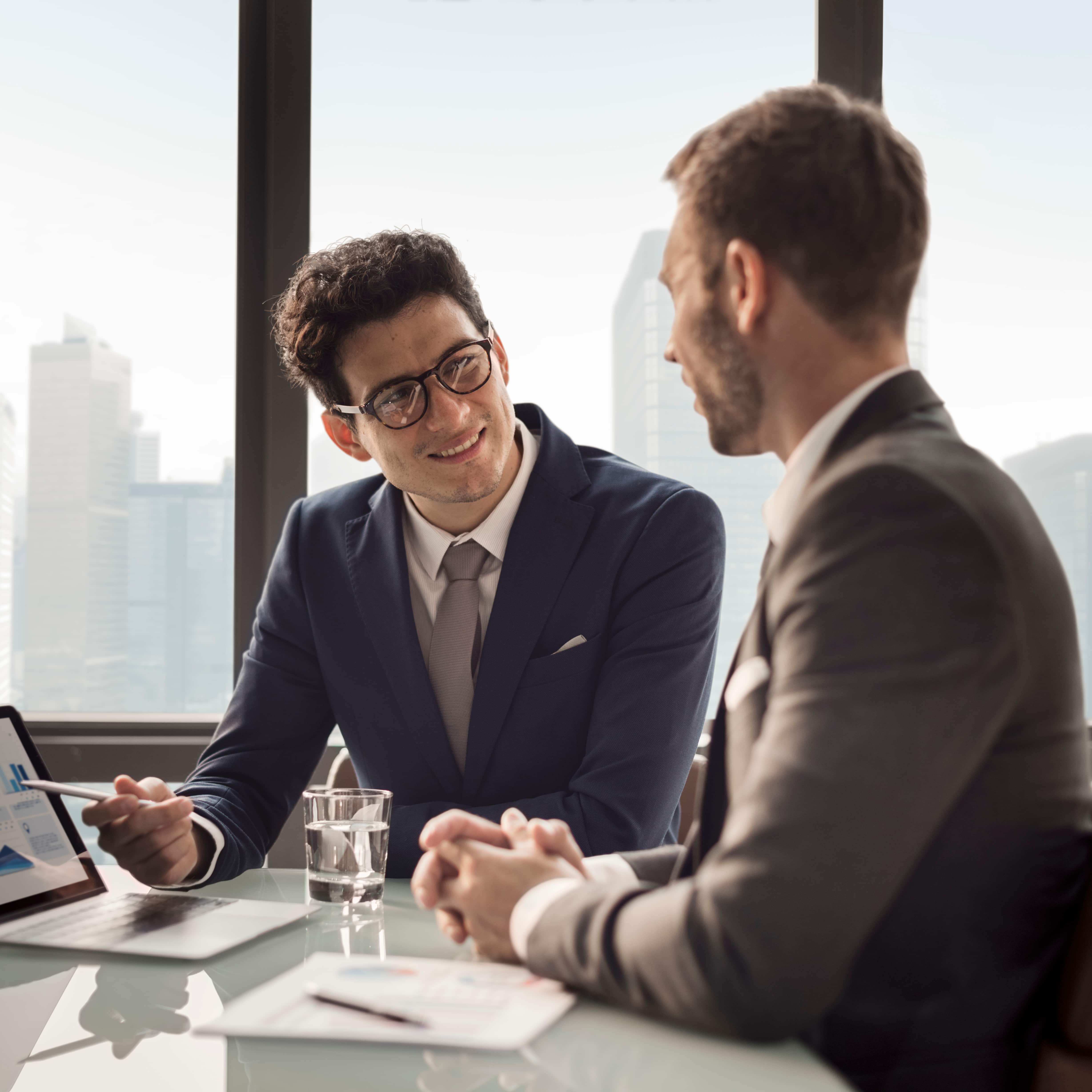 Directivo recibiendo executive coaching en Madrid, sentado en una oficina moderna con vistas urbanas, enfocado en liderazgo empresarial